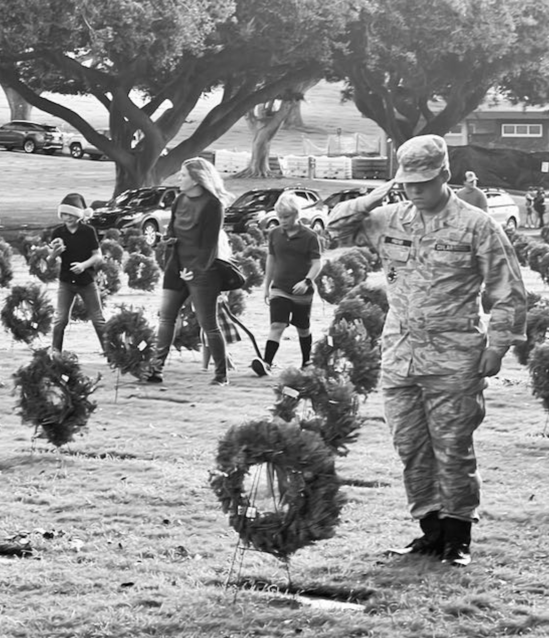 Uniformed soldier salutes a grave at the National Memorial Cemetery of the Pacific (Punchbowl)